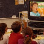 Alumnos observando un comercial en el aula
